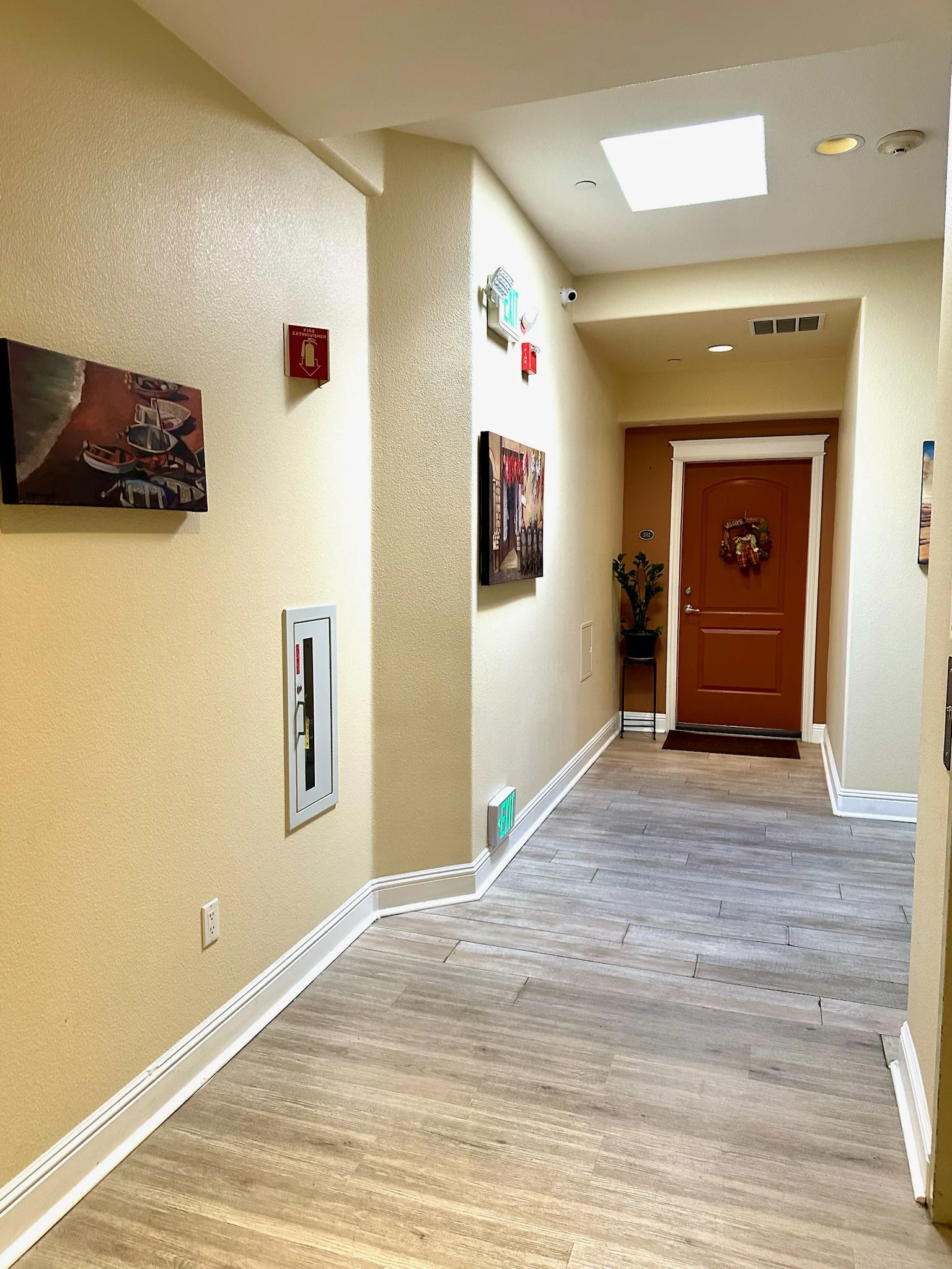 Wide hallway with skylight and artwork at Monterey Terrace luxury apartments Gilroy