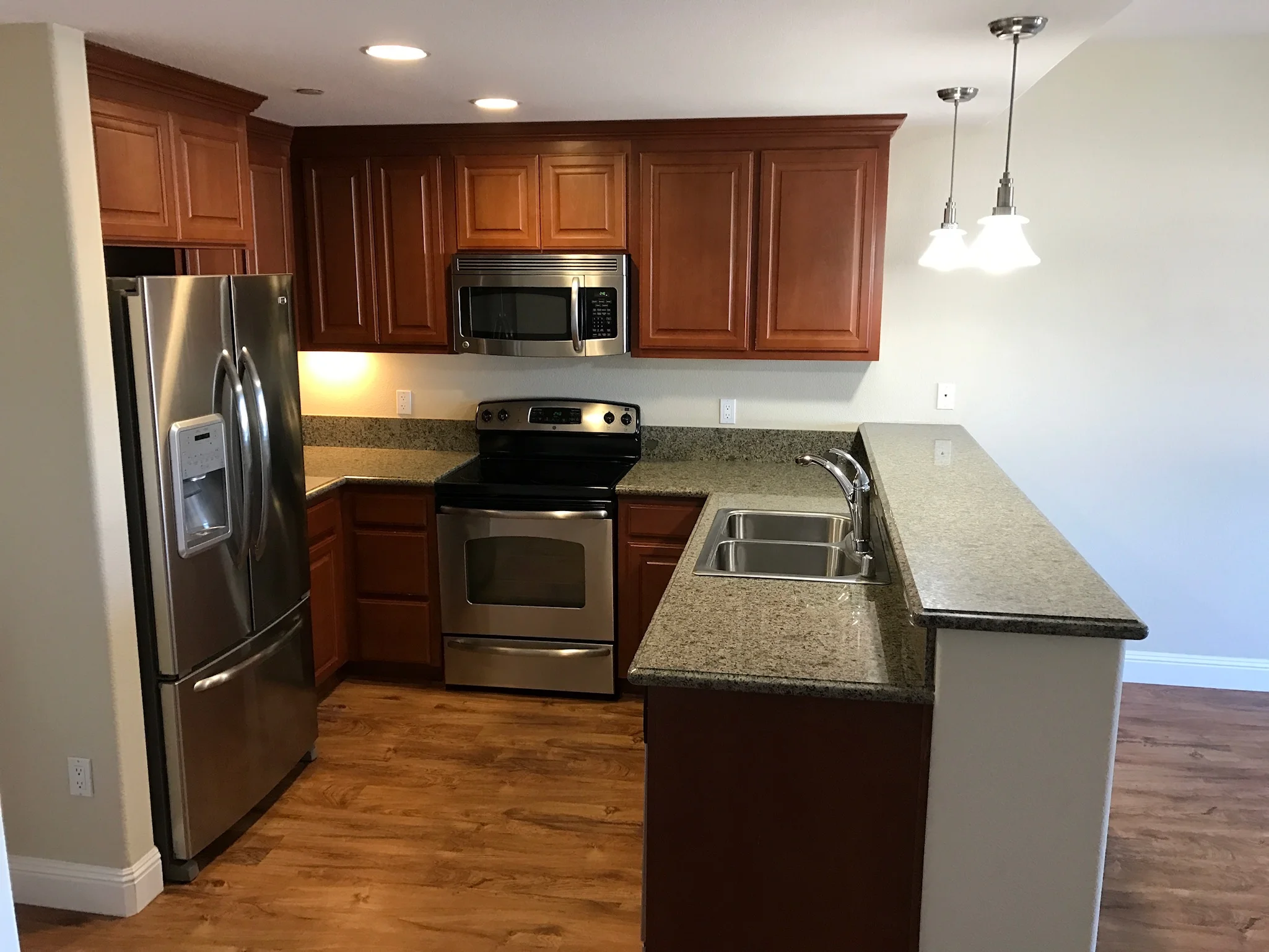Full kitchen view with breakfast bar and stainless steel appliances at Monterey Terrace Gilroy