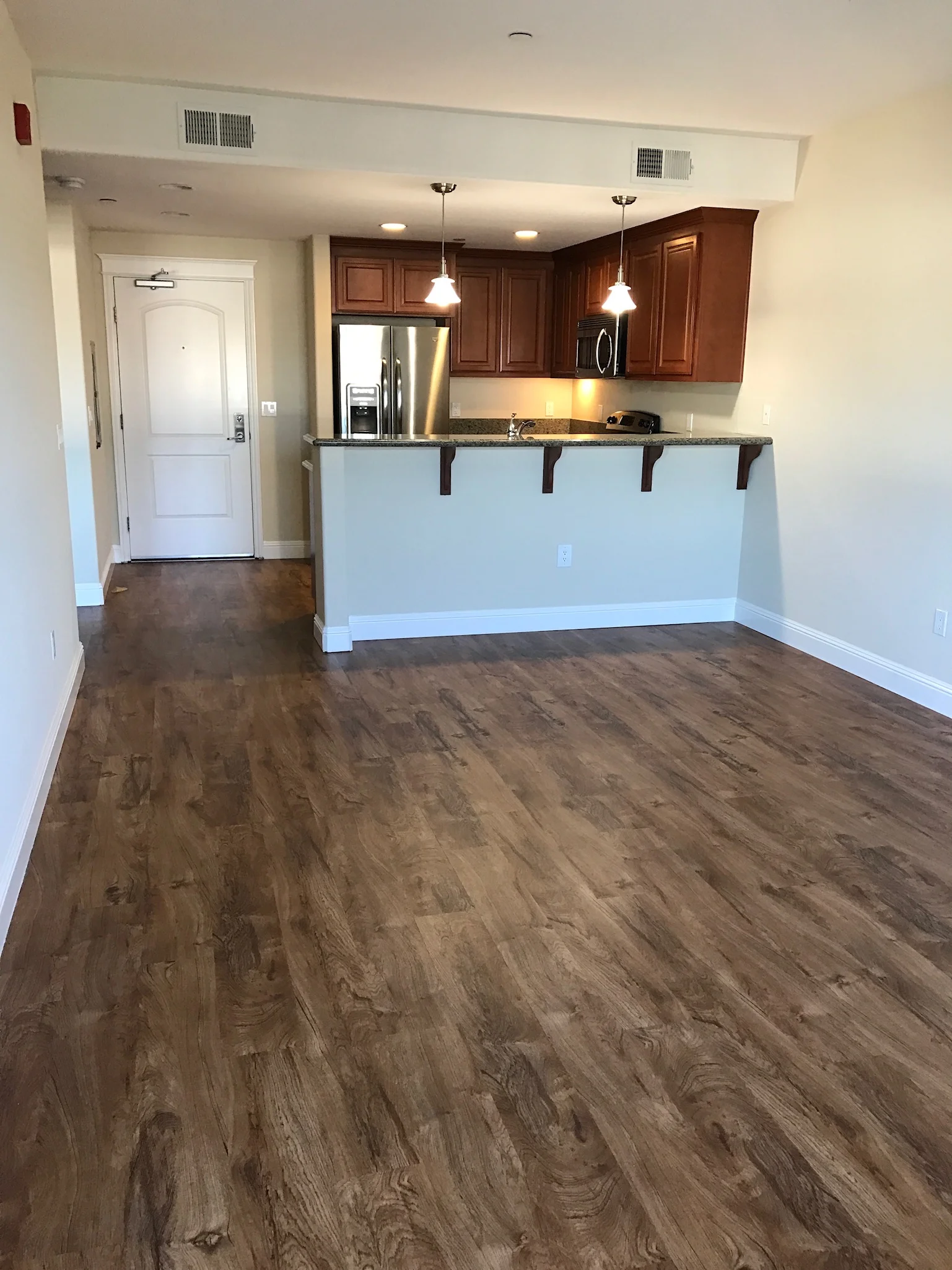 Open concept living with pendant lights in downtown Gilroy luxury apartment